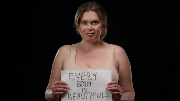 Portrait of Smiling Confident Plus Size Caucasian Woman Raising Message Every Body is Beautiful