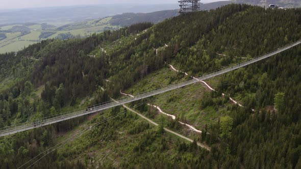 People crossing world's longest suspension footbridge, Czechia, drone.