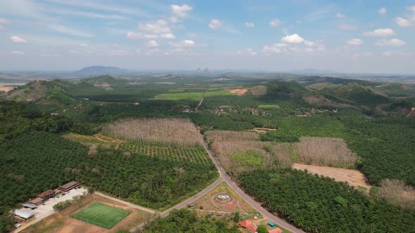 Aerial drone of a large green valley in the rural mountain region of Krabi Thailand on a sunny day