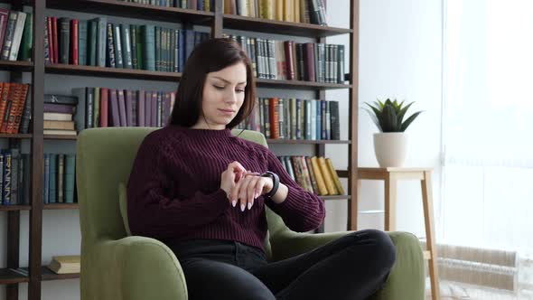 Woman Using Smartwatch while Sitting on Sofa
