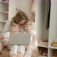 Mom with Twin Daughters at the Laptop on the Background of the Closet - VideoHive Item for Sale