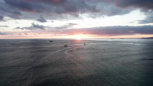 Low aerial shot of boats on the ocean during sunset off the coast of O'ahu, Hawaii. 4K