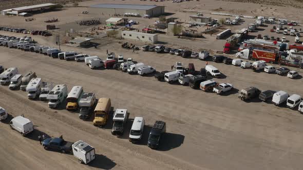 Aerial tilt up over lines of motorhomes parked in an Arizona desert