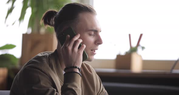 Businessman Working By Laptop PC in a Cafe and Talking By Phone