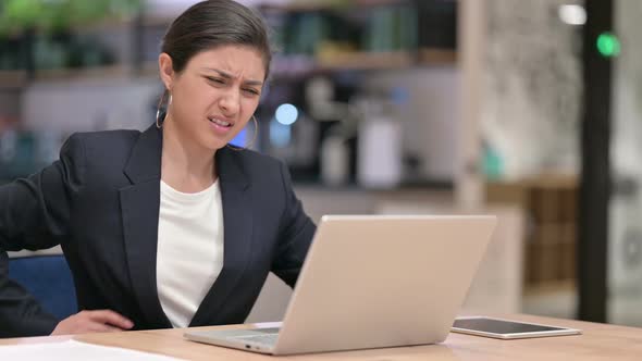 Tired Young Indian Businesswoman with Laptop Having Back Pain in Cafe