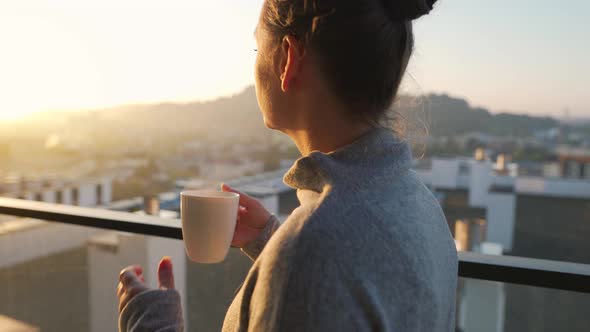 Woman Starts Her Day with a Cup of Tea or Coffee on the Balcony at Dawn Slow Motion