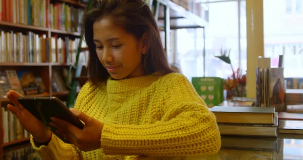 Teenage girl using digital tablet in library 4k