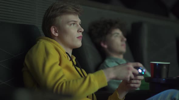 Gamers Playing in a Movie Theater Two Friends Playing Video Games on a Game Console Playing Games on