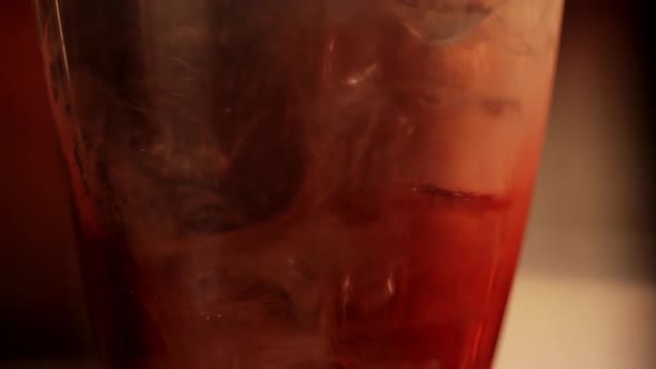 Lime juice blending with other cocktail ingredients, close-up