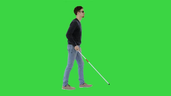 Blind Young Man with a Cane Walking on a Green Screen, Chroma Key