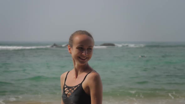 Happy Tourist Walks Along Beach Against Boundless Ocean