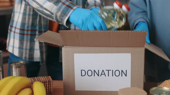 Volunteers in Gloves Preparing Boxes for Donation