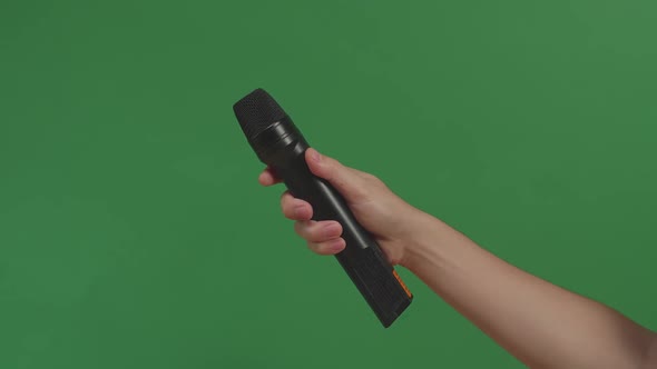 Male Hand Holding Microphone Against Background Green Screen Chroma Key. Close Up Mic