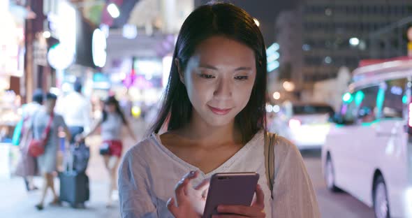 Woman use of mobile phone in the city at night