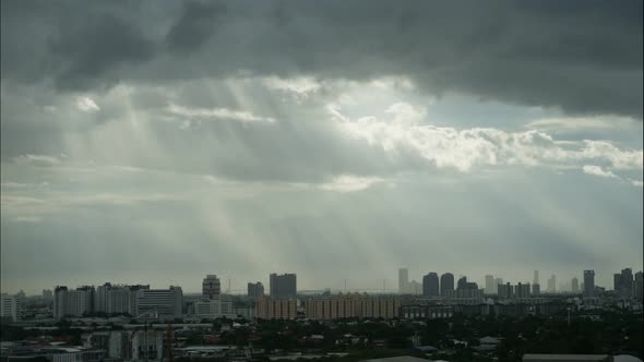 Time lapse sunlight ray on cityscape and storm cloudy blue sky smoothly flowing