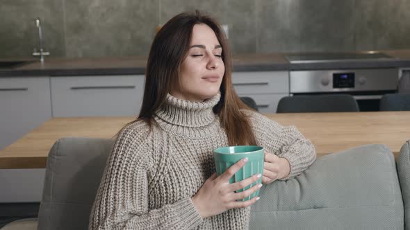 Portrait of Satisfied Young Woman Drinking Tea of Modern Apartmant