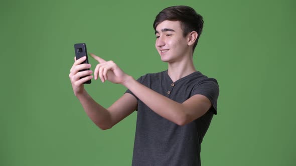 Young Handsome Iranian Teenage Boy Against Green Background