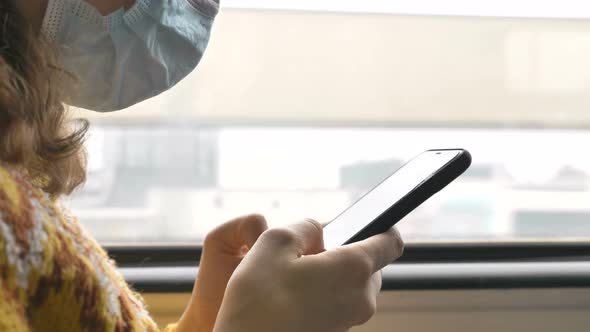 Woman in Disposable Mask Uses Phone in Public Transport