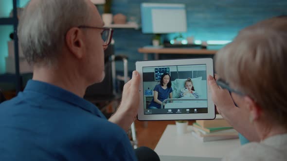 Senior Grandparents Using Videoconference to Talk to Family in Hospital