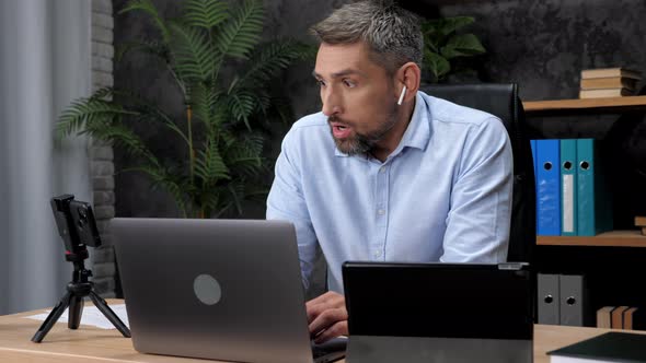 Shocked Businessman Looks at Laptop Tablet and Smartphone Screen Display