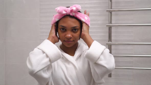 A AfricanAmerican Woman Puts a Bandage on Her Hair to Wash Her Face