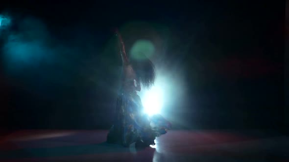 Young Girl in Blue Oriental Costume Dancing Belly Dance, on Black, Smoke, Back Light