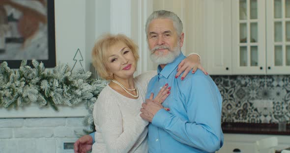 Senior Family Couple Hugging Smiling Looking at Camera Elderly Old Adult Grandparents Husband