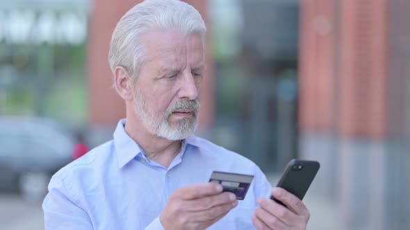 Outdoor Old Man Using Credit Card on Smartphone