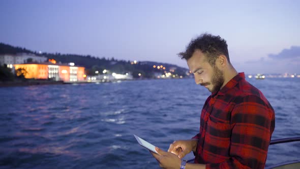 Man using tablet in watercraft. Happy.