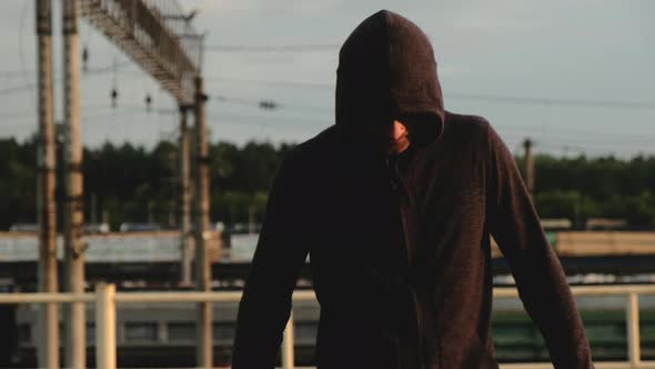 Portrait of male athlete on roof in evening at sunset during training.