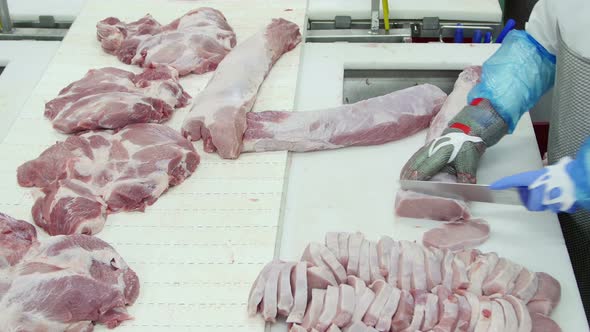 Butcher Who Cuts Meat In A Meat Processing Factory