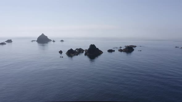 Small jagged rocks in shallow ocean water present navigation hazard