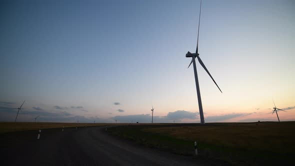 Landscape View of Windmills Farm Wind Generators for Energy Production on Sunset