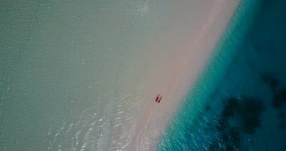 Fun lady and man on romantic honeymoon live the dream on beach on sunny white sandy background