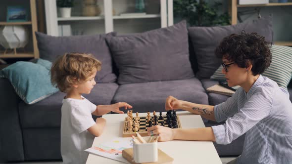 Little Boy Is Happy After Chess Game Celebrating and Doing High-five with Mother