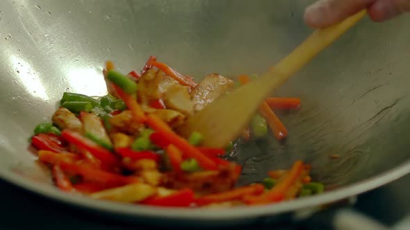 Cook Prepares Fresh Vegetables in a Frying Pan in Boiling Oil Stir with a Wooden Spatula 1