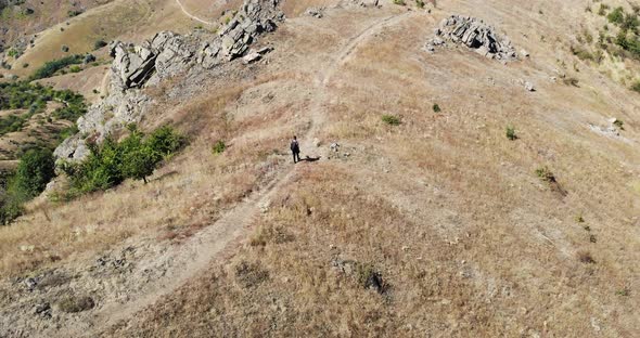 Lone Man Walks On Macin Mountain Range In Romania On A Sunny Summer Day