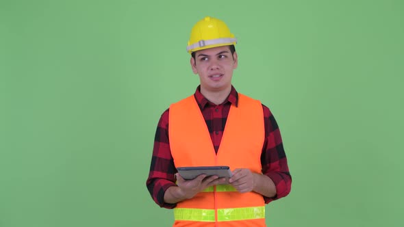 Happy Young Multi Ethnic Man Construction Worker Talking While Using Digital Tablet