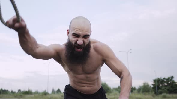 Athlete Trains On The Street. Strong Young Man With Beard.