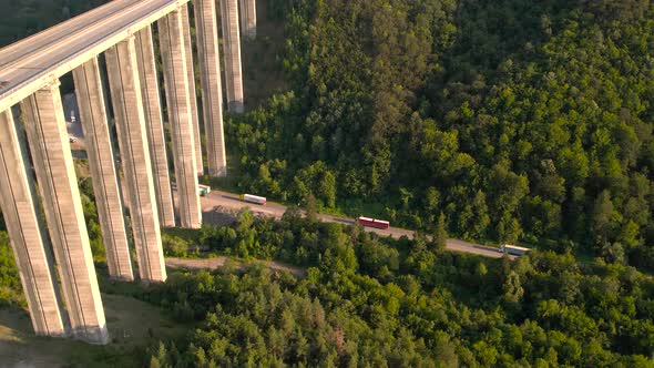 Aerial View of Trucks in Traffic Under Viaduct Highway Bridge in the Mountains