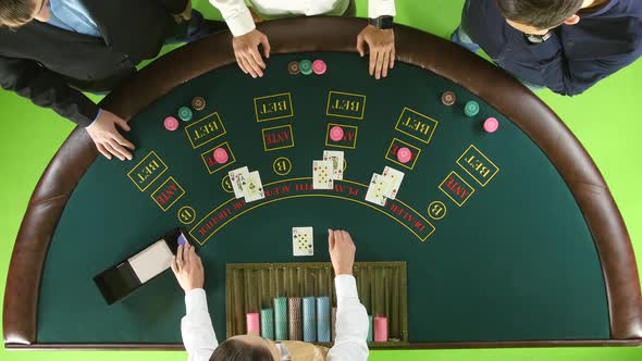 People Playing Poker at the Table, the Dealer Deals the Cards. Green Screen. Top View