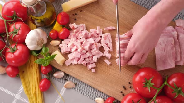 Making Pasta Carbonara Slicing Traditional Pancetta Bacon Into Pieces on a Wooden Cutting Board with