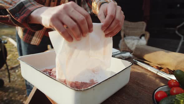 Man Patting Meat Dry with Paper Towels before Cooking on BBQ