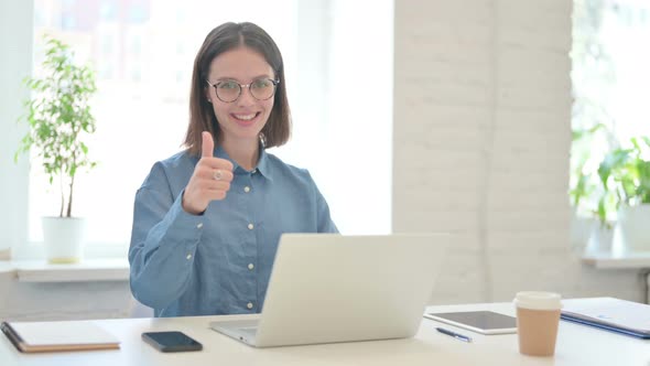 Thumbs Up by Young Woman Working on Laptop