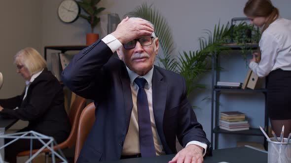 Bored Senior Man Boss Doing Face Palm Gesture While Developing New Project on Laptop Computer