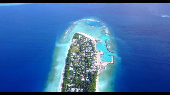 Aerial drone shot panorama of tropical tourist beach voyage by blue green lagoon and white sand back