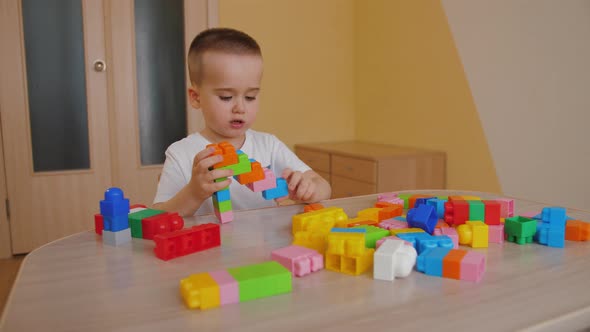 Funny Baby Boy Playing with Colorful Building Blocks Assembling Toy Bricks