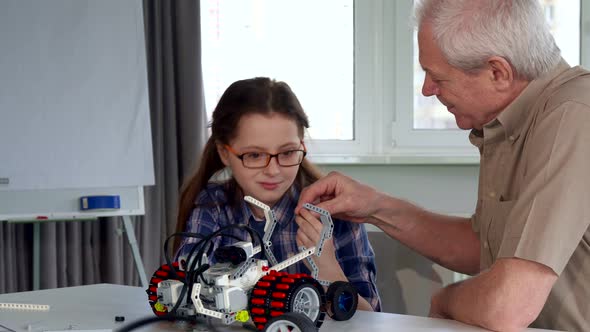 Senior Man Gives His Granddaughter the Part From Toy Vehicle