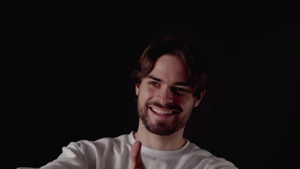 Trendy Young Man giving thumbs up, appreciative gesture, close, black background