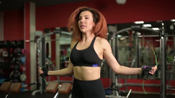 Close-up of a young woman jumping rope in the gym